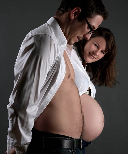 Lüstige Babybauchfotos mit dem Mann im Fotostudio Wagner München