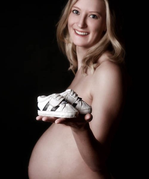 Babybauchfoto mit Babyschuhen